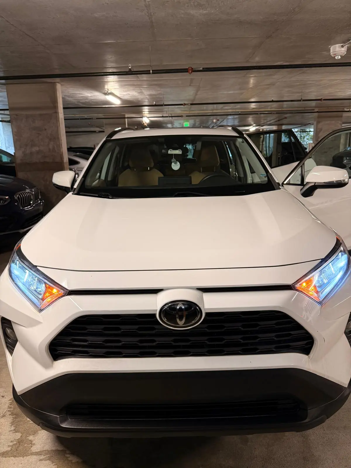 Before and after mobile hand wash on white Toyota RAV4 front bumper in Fort Lauderdale — dirt and splatter removed by Route95